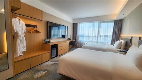 a hotel room with two beds and a desk at Yanshan Hotel in Beijing