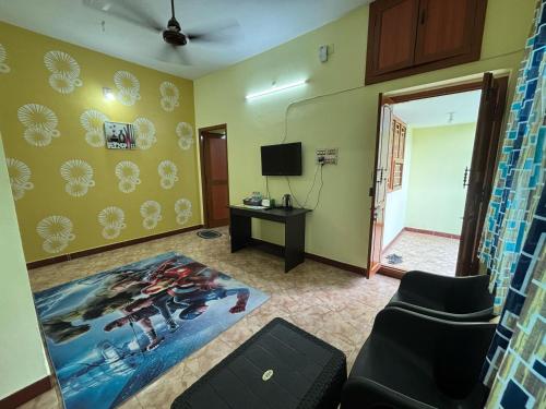 a living room with a couch and a television at V2V Homestay in Mayiladuthurai