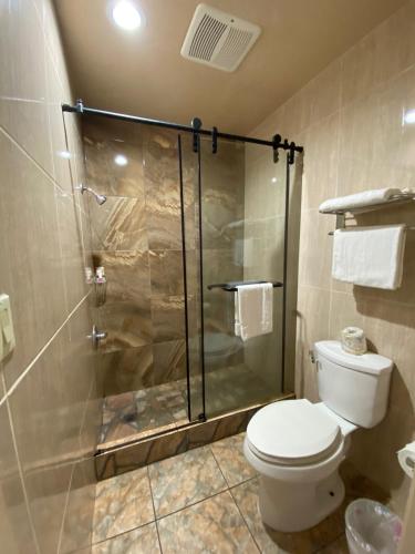 a bathroom with a toilet and a glass shower at Dream Inn in Inglewood
