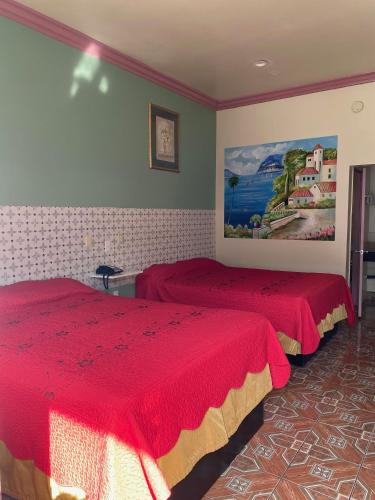 a bedroom with two beds and a painting on the wall at Dream Inn in Inglewood