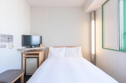 a hospital room with a bed and a tv at Washington R&B Hotel Hakata Ekimae 1 in Fukuoka