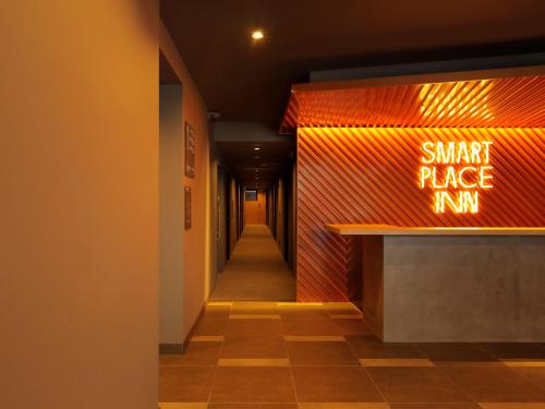 a hallway with a small price run sign on a wall at Smart Place Inn Kyoto Shijo Horikawa in Kyoto