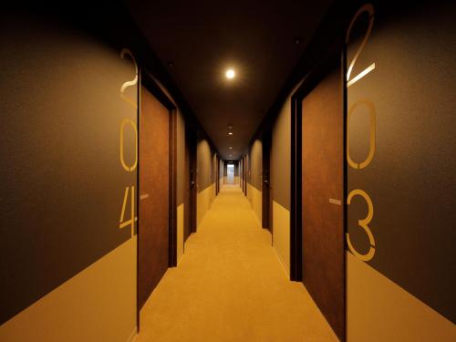 a hallway with doors and a long corridor at Smart Place Inn Kyoto Shijo Horikawa in Kyoto