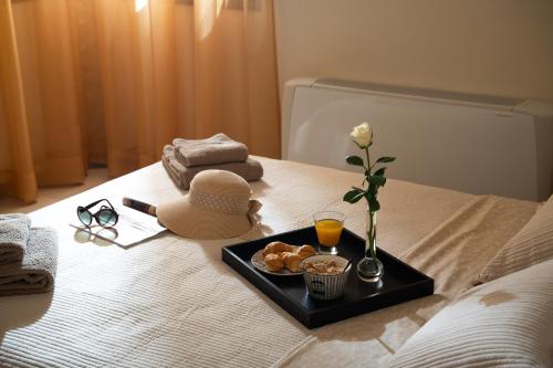 a tray of food and a vase of flowers on a bed at Silva Luxury House in Mires (South Crete) in Moírai