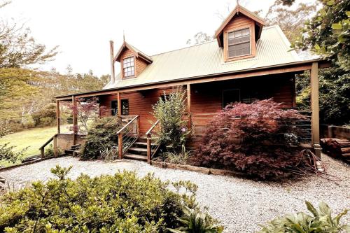 a log cabin with a staircase in front of it at Imis Cottage in Katoomba