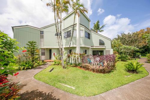 プリンスビルにあるSpacious Getaway Condo Near Beach & Golf 1st Floorの前にヤシの木がある家