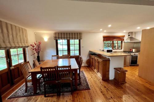 a kitchen and dining room with a table and chairs at Imis Cottage in Katoomba