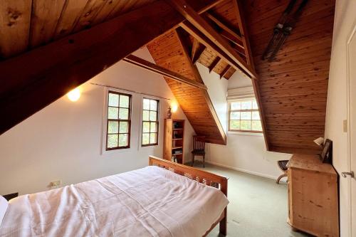 a bedroom with a large bed in a attic at Imis Cottage in Katoomba
