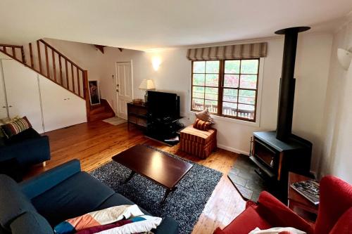 a living room with a couch and a wood stove at Imis Cottage in Katoomba