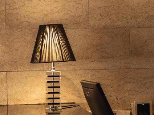 a lamp sitting on a desk next to a computer monitor at Nishitetsu Inn Tenjin in Fukuoka
