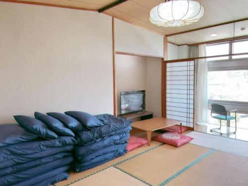 a living room with a couch and a table at Sky Villa 湯河原 個室Ocean View 無料駐車無料送迎 in Mongawa