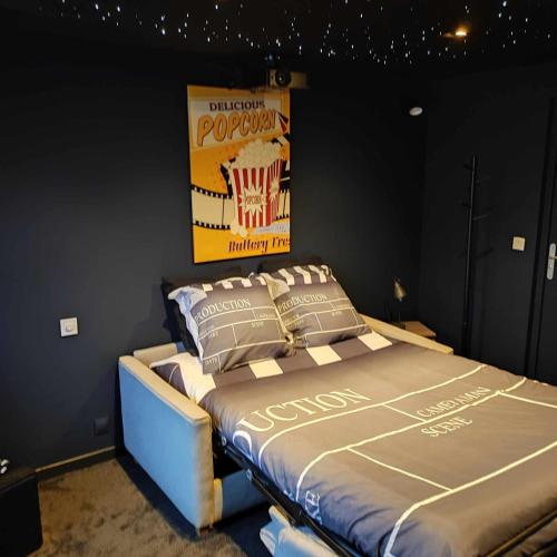 Ce lit se trouve dans une chambre dotée d'une affiche murale. dans l'établissement L'évasion popcorn, à Saint-Pierre-de-Plesguen