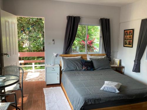 a bedroom with a bed and a table and a window at Seasalt 1 Cozy Studio with Full kitchen and fast WiFi in Thong Sala