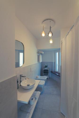 a bathroom with a sink and two toilets and a mirror at Hotel Due Palme in Mergozzo
