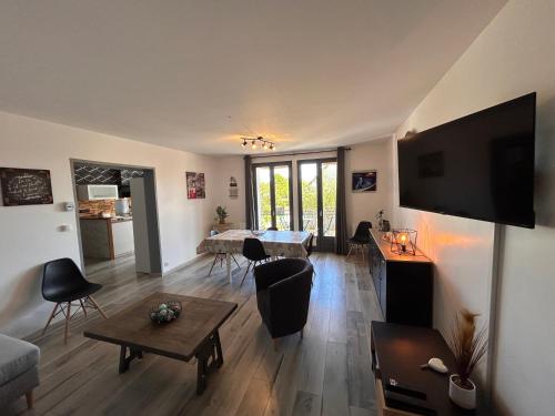 a living room with a table and a television on a wall at Maison de vacances avec terrasse - 6 personnes in Montagny-lès-Beaune