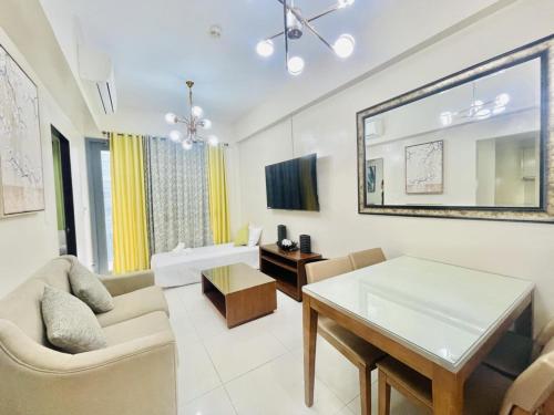 a living room with a couch and a table at MACTAN NEWTOWN FAMILY ROOM Deluxe with free wi-fi, POOL & GYM in Lapu Lapu City
