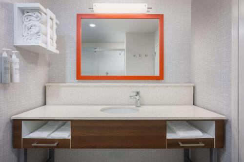 an orange mirror above a sink in a bathroom at Hampton Inn & Suites Birmingham-Pelham - I-65 in Pelham