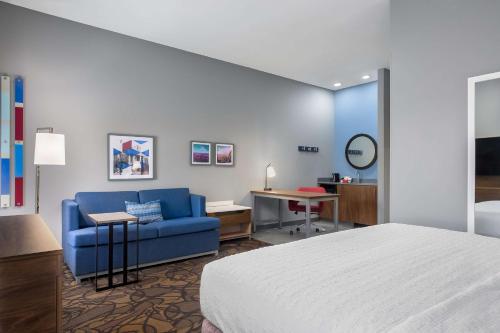a hotel room with a bed and a blue couch at Hampton Inn & Suites Birmingham-Pelham - I-65 in Pelham