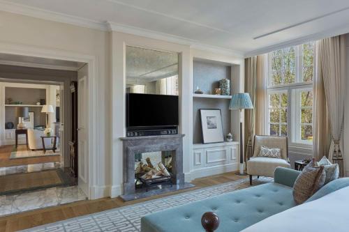 a living room with a fireplace and a television at Waldorf Astoria Amsterdam in Amsterdam