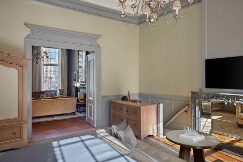 a living room with a fireplace and a tv at Waldorf Astoria Amsterdam in Amsterdam