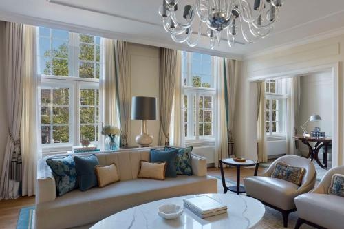 a living room with a couch and a chandelier at Waldorf Astoria Amsterdam in Amsterdam