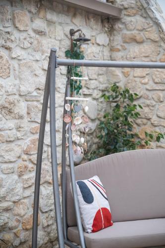 a chair with a pillow on it next to a stone wall at Silva Luxury House in Mires (South Crete) in Moírai