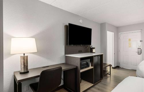 a room with a desk with a television and a bed at La Quinta Inn by Wyndham Stockton in Stockton