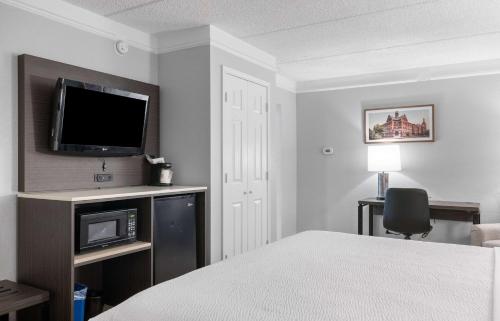 a hotel room with a bed and a flat screen tv at La Quinta Inn by Wyndham Stockton in Stockton