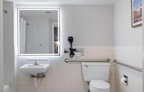 a bathroom with a toilet and a sink and a mirror at La Quinta Inn by Wyndham Stockton in Stockton