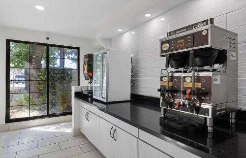 a kitchen with a black counter top with a machine at La Quinta Inn by Wyndham Stockton in Stockton
