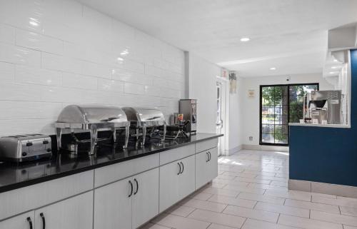 a kitchen with a counter top with stools at La Quinta Inn by Wyndham Stockton in Stockton