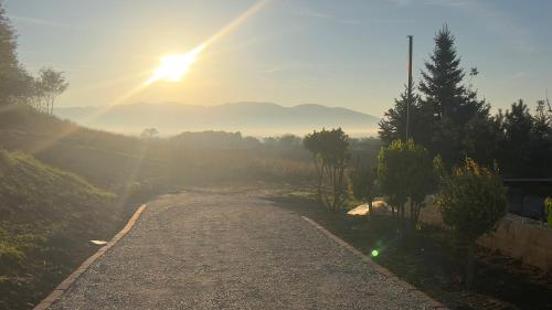 a dirt road with the sun in the sky at Villa Beelvita&Jacuzzi in Bielovce