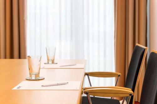 a table and chairs with glasses on top of it at Best Western Plus Hotel Papenburg in Papenburg