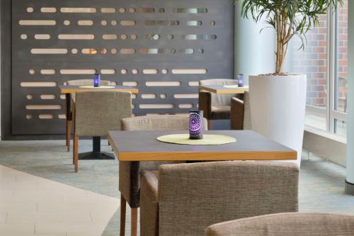 a dining room with chairs and a table with a vase at Best Western Plus Hotel Papenburg in Papenburg