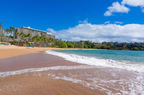 a view of a beach with a building and the ocean at Beachfront Bungalow Walk to Ocean & Restaurants in Lihue