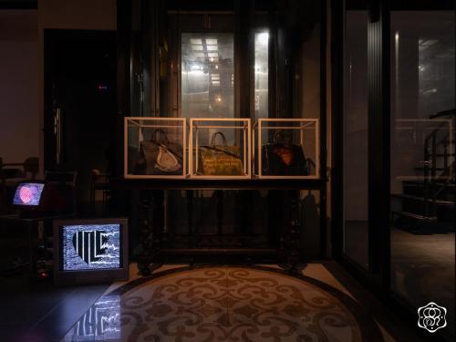 a shelf with purses and a television in a room at Amanaki Saigon Boutique Hotel in Ho Chi Minh City