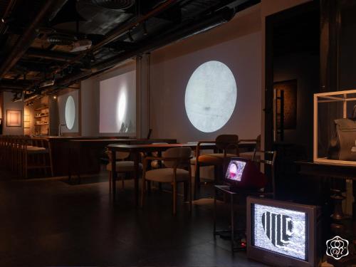 a room with tables and chairs and a moon on the wall at Amanaki Saigon Boutique Hotel in Ho Chi Minh City