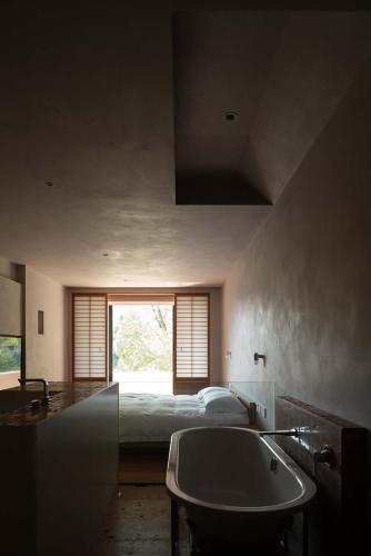 a bedroom with a bed and a sink and a tub at Rakuhotel in Wenzhou