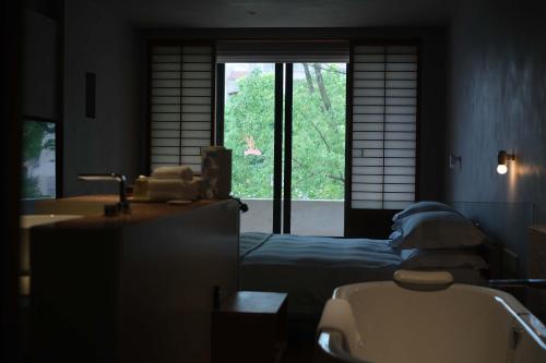 a bathroom with a bed and a sink and a window at Rakuhotel in Wenzhou