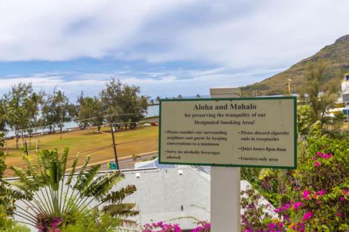 a sign in front of a park with flowers at Beachfront Bungalow Walk to Ocean & Restaurants in Lihue