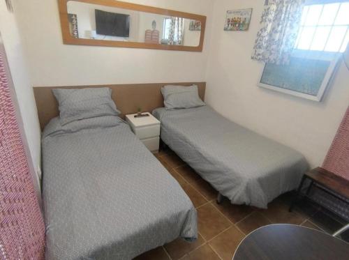 a room with two beds and a mirror on the wall at Beachfront Studio with Private Kitchen and Bath in Algeciras