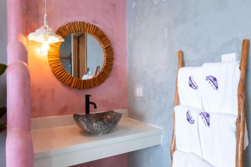 a bathroom with a mirror and a sink and towels at Chiu Chiu Resort Đảo Phú Quý in Cu Lao Thu