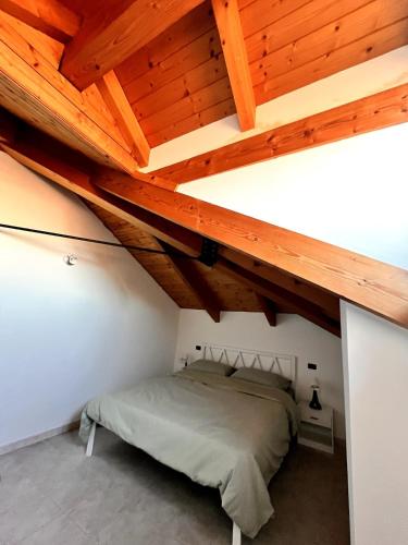 a bedroom with a bed under a wooden ceiling at La quiete in centro in Chivasso