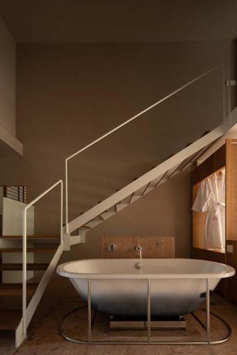 a bathroom with a bath tub and a staircase at Rakuhotel in Wenzhou