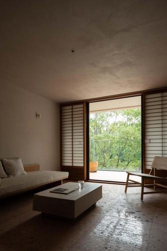 a living room with a bed and a large window at Rakuhotel in Wenzhou