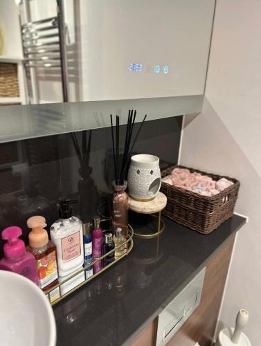 a bathroom counter with a sink and a basket of cosmetics at Charming Dartford Apartment with 1 Bedroom in Dartford