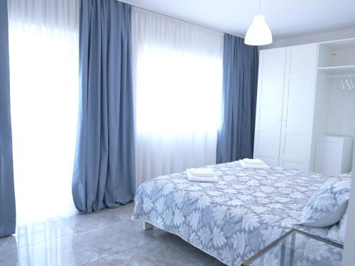 a bedroom with a bed with blue curtains at Lux House Olga in Ruma