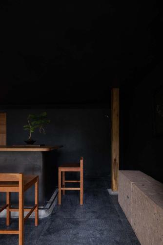 a room with a table and two chairs and a plant at Rakuhotel in Wenzhou