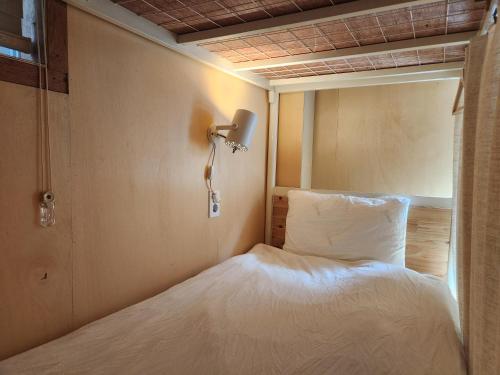 a bedroom with a bed and a lamp on the wall at Sokcho Hutte in Sokcho