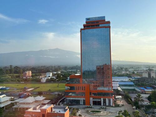 a tall building in a city with a mountain at Hotel Anda China Malabo in Malabo